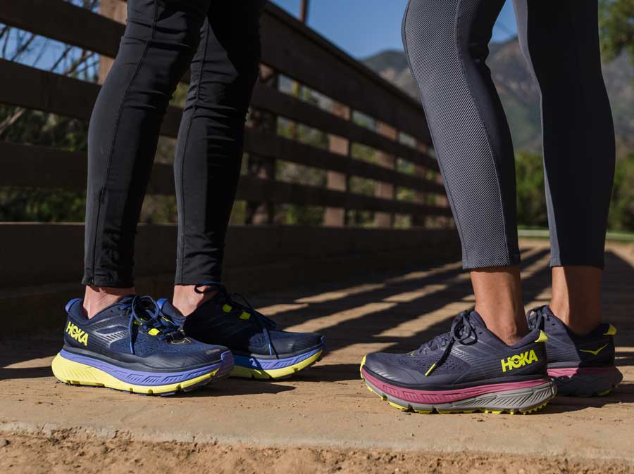 A close up for two people wearing HOKA shoes