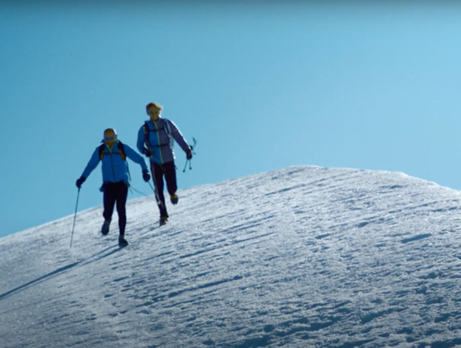 Two people running down a snowy hill